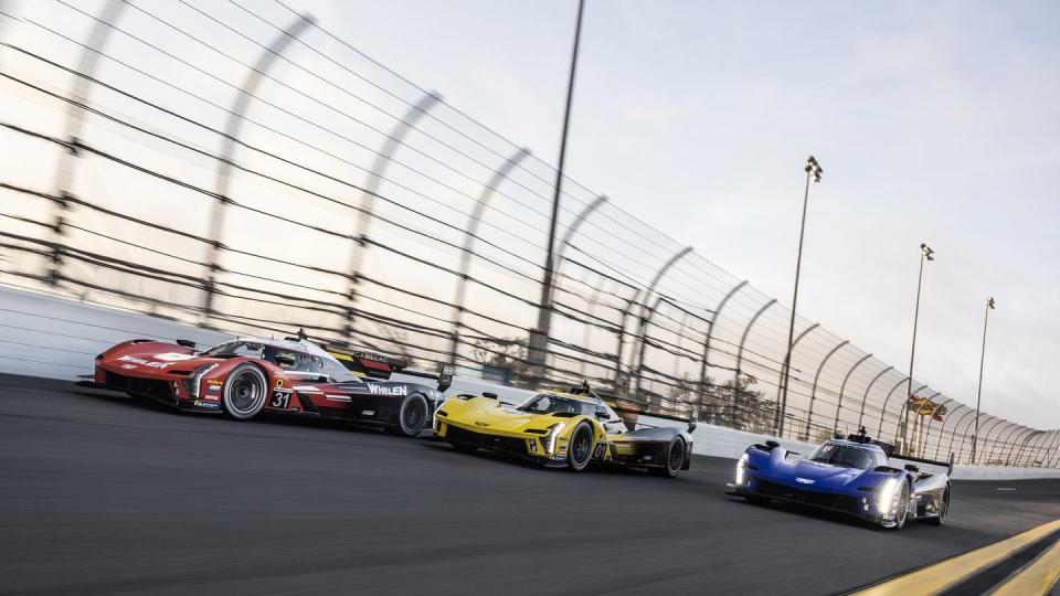 front 34 view of the left to right red, gold and blue cadillac v seriesr race cars on track richard princecadillac photo