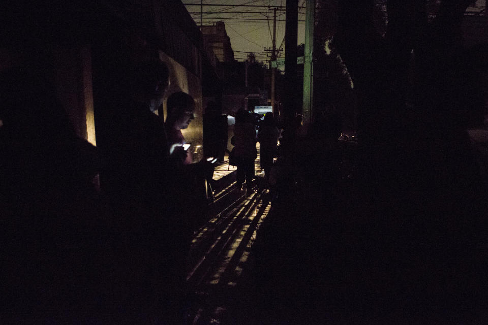 <p>People who evacuated from bars check their phones in the street in La Roma neighborhood of Mexico City, after an earthquake shook buildings forcefully and knocked out power in the area, just before midnight on Thursday, Sept. 7, 2017. (AP Photo/Rebecca Blackwell) </p>