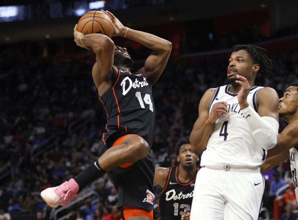 Detroit Pistons guard Alec Burks (14) goes to the basket against Brooklyn Nets guard Dennis Smith Jr. (4) during the first half of an NBA basketball game Tuesday, Dec. 26, 2023, in Detroit. (AP Photo/Duane Burleson)