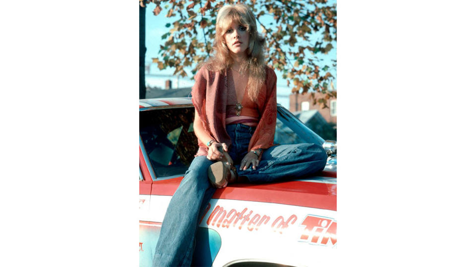 Stevie Nicks sitting on car