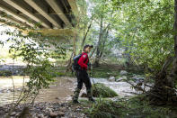 <p>A Navajo County rescuer searches the riverbank under the bridge where one body was recovered in Tonto National Forest, Ariz., Monday, July 17, 2017. Rescuers continue the search for a missing 27-year-old man, who was swept downriver with more than a dozen others when floodwaters inundated the area on Saturday. (AP Photo/Angie Wang) </p>