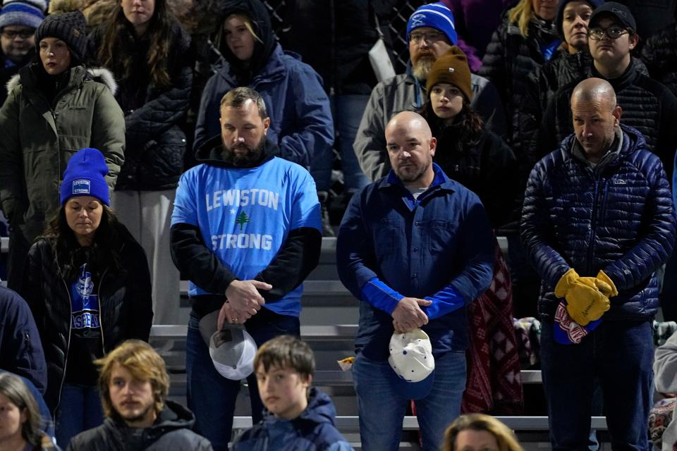 Lewiston High School fans stand during a moment of silence for the victims of the Lewiston shooting, Wednesday, Nov. 1, 2023, prior to a high school football game against Edward Little High School in Lewiston, Maine. Locals seek a return to normalcy after the mass shooting on Oct. 25. (AP Photo/Matt York)