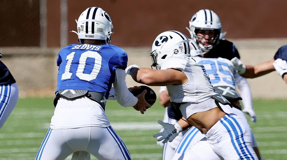 Quarterback Kedon Slovis, hands off to running back Hinckley Ropati, as BYU practices in Provo on Friday, March 17, 2023. | Scott G Winterton, Deseret News