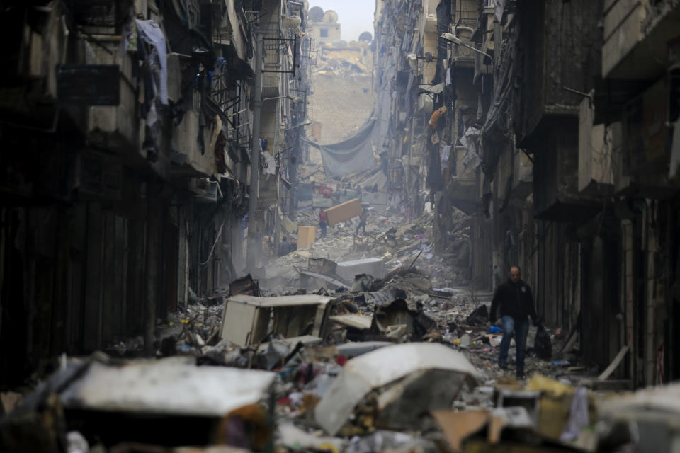 FILE - Residents walk through the destruction of the once rebel-held Salaheddine neighborhood in the eastern Aleppo, Syria, Friday, Jan. 20, 2017. For years, the people of Aleppo bore the brunt of bombardment and fighting when their city, once Syria's largest and most cosmopolitan, was one of the civil war's fiercest battle zones. Even that didn't prepare them for the new devastation and terror wreaked by this week's earthquake. (AP Photo/Hassan Ammar, File)