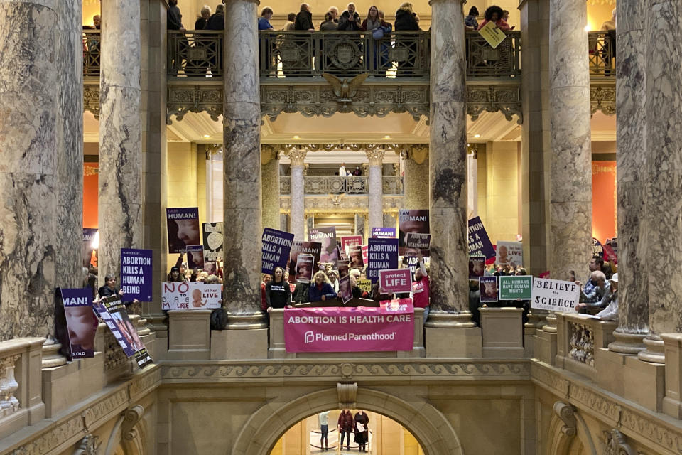 Abortion protesters on both sides pack the halls outside the Minnesota Senate chamber on Friday, Jan. 27, 2023, at the State Capitol in St. Paul, Minn. The Minnesota Senate is debating a bill Friday to write broad protections for abortion rights into state statutes, which would make it difficult for future courts to roll back. (AP Photo/Steve Karnowski)
