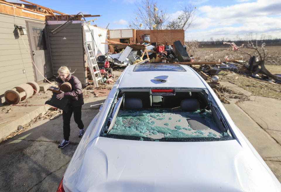 Marie Rickard assists her neighbor retrieving items from her home following a tornado in Porter, Wis. Friday, Feb. 9, 2024. The first tornado ever recorded in Wisconsin in the usually frigid month of February came on a day that broke records for warmth, the type of severe weather normally seen in the late spring and summer. (John Hart/Wisconsin State Journal via AP)