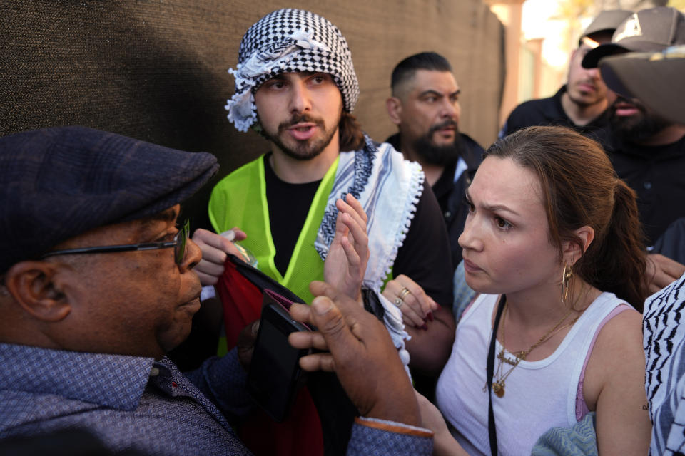 Pro-Palestinian demonstrators, at right, attempt to keep attendees from getting through at the Shrine Auditorium where a commencement ceremony for graduates from Pomona College was being held, Sunday, May 12, 2024, in Los Angeles. (AP Photo/Ryan Sun)