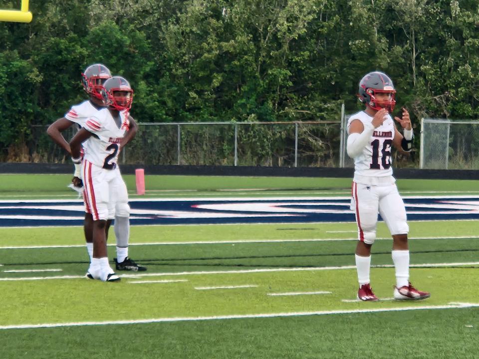 A.J. Ellender football players warm up.