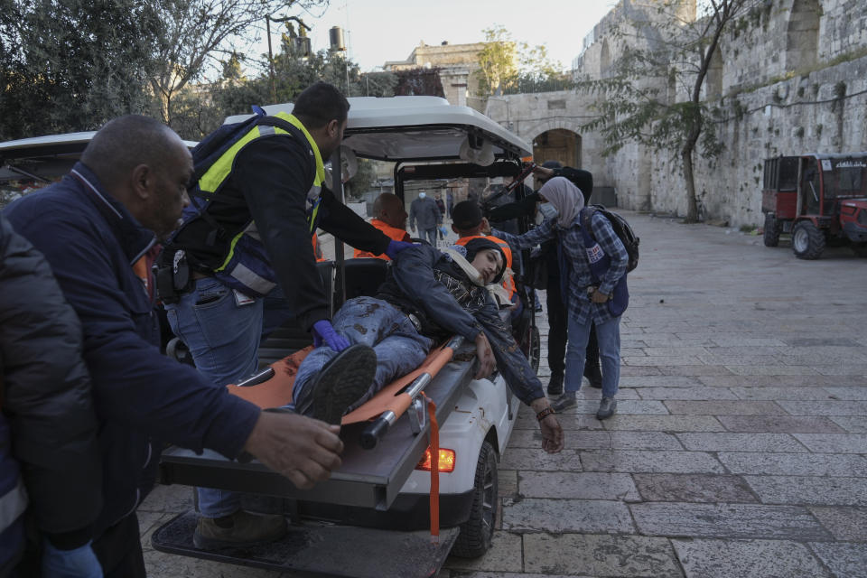 Palestinians evacuate a wounded man during clashes with Israeli security forces, outside Al Aqsa Mosque compound in Jerusalem's Old City Friday, April 15, 2022. (AP Photo/Mahmoud Illean)