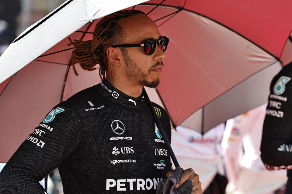 Mercedes driver Lewis Hamilton of Britain holds an umbrella prior to the start of the Azerbaijan Formula One Grand Prix at the Baku circuit, in Baku, Azerbaijan, Sunday, June 12, 2022. (Hamad Mohammed, Pool Via AP)