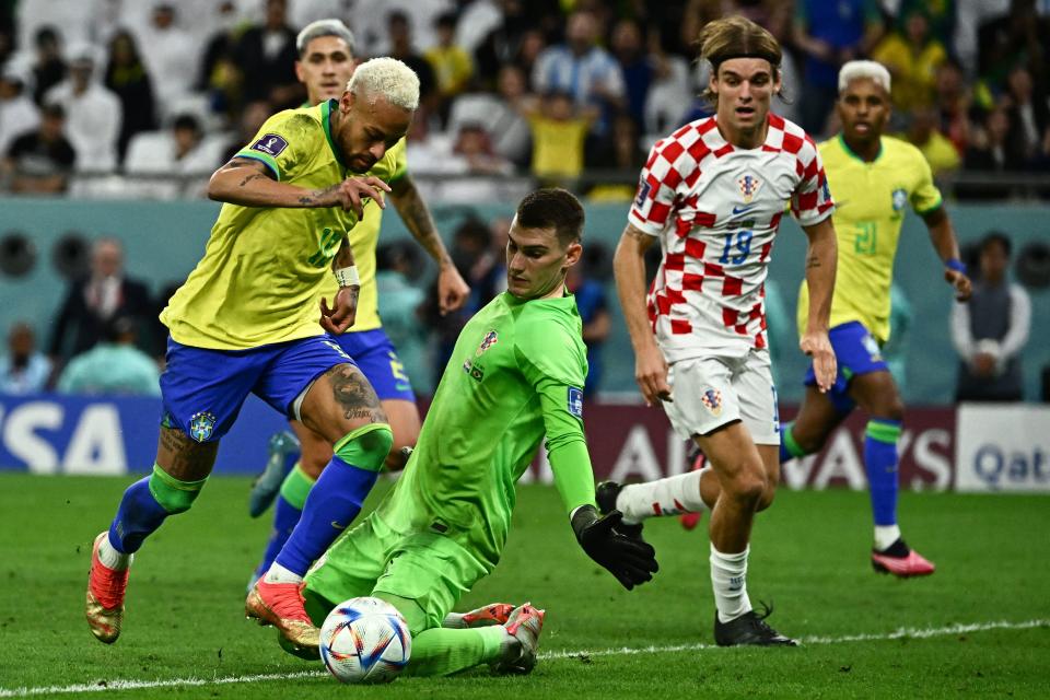 TOPSHOT - Brazil's forward #10 Neymar eludes Croatia's goalkeeper #01 Dominik Livakovic to score his team's first goal during the Qatar 2022 World Cup quarter-final football match between Croatia and Brazil at Education City Stadium in Al-Rayyan, west of Doha, on December 9, 2022. (Photo by Jewel SAMAD / AFP) (Photo by JEWEL SAMAD/AFP via Getty Images)