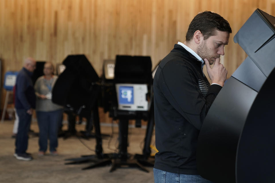 Tony Bergida looks over an electronic ballot while voting early at a polling place, Thursday, Oct. 27, 2022, in Olathe, Kan. Bergida, a 27-year-old father of two and the chair of the Kansas Young Republicans, said the top issue on his mind as he cast his ballot was the economy. (AP Photo/Charlie Riedel)