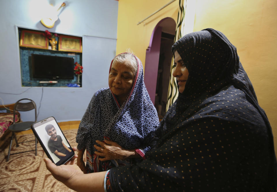 Nazima Shaikh, right, mother of Arbaz Mullah smiles as she watches with her mother a video clip featuring Mullah at her home in Belagavi, India, Oct. 6, 2021. Arbaz Mullah was a Muslim man in love with a Hindu woman. But the romance so angered the woman’s family that — according to police — they hired members of a hard-line Hindu group to murder him. It's a grim illustration of the risks facing interfaith couples as Hindu nationalism surges in India. (AP Photo/Aijaz Rahi)