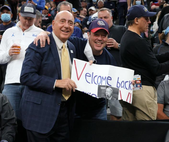 ESPN college basketball analyst Dick Vitale poses with a fan holding a sign welcoming him back before a game between the No. 1 Gonzaga Bulldogs and the No. 2 UCLA Bruins.