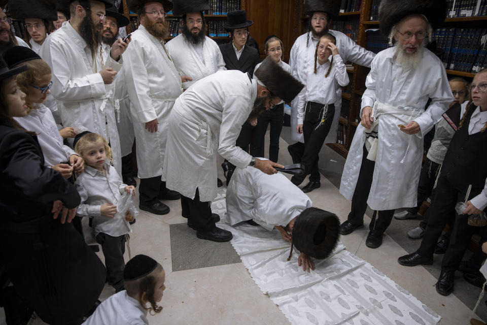 An ultra-Orthodox Jewish man whips a member of his Hasidic dynasty with a leather strap as a symbolic punishment for his sins last year, during the traditional Malkot (whipping in Hebrew) ceremony, ahead of Yom Kippur that begins at sunset, in the city of Beit Shemesh, near Jerusalem, Wednesday, Sept. 15, 2021. Yom Kippur is Judaism's day of atonement, when devout Jews ask God to forgive them for their transgressions and refrain from eating and drinking, attending intense prayer services in synagogues. (AP Photo/Oded Balilty)