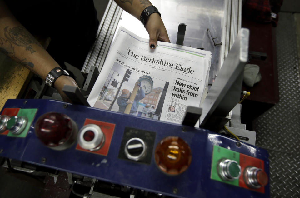 In this Thursday, April 11, 2019 photo, copies of The Berkshire Eagle newspaper are placed in a machine before being bundled for distribution, in Pittsfield, Mass. The paper now features a new 12-page lifestyle section for Sunday editions, a reconstituted editorial board, a new monthly magazine, and the newspaper print edition is wider. That level of expansion is stunning in an era where U.S. newspaper newsroom employment has shrunk by nearly half over the past 15 years. (AP Photo/Steven Senne)