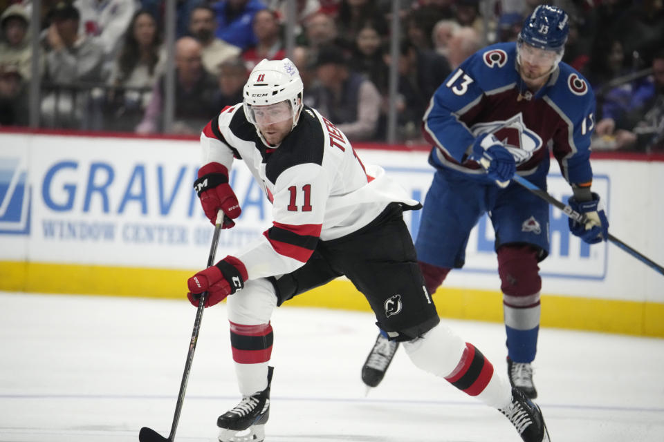 New Jersey Devils center Chris Tierney (11) moves the puck past Colorado Avalanche right wing Valeri Nichushkin in the second period of an NHL hockey game on Tuesday, Nov. 7, 2023, in Denver. (AP Photo/David Zalubowski)