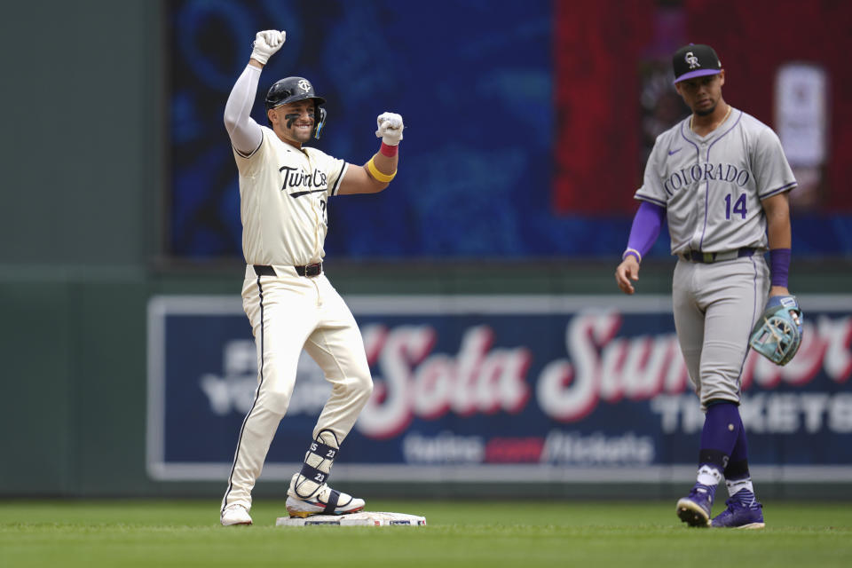 Minnesota Twins' Royce Lewis, left, celebrates after hitting a double during the eighth inning of a baseball game against the Colorado Rockies, Wednesday, June 12, 2024, in Minneapolis. (AP Photo/Abbie Parr)