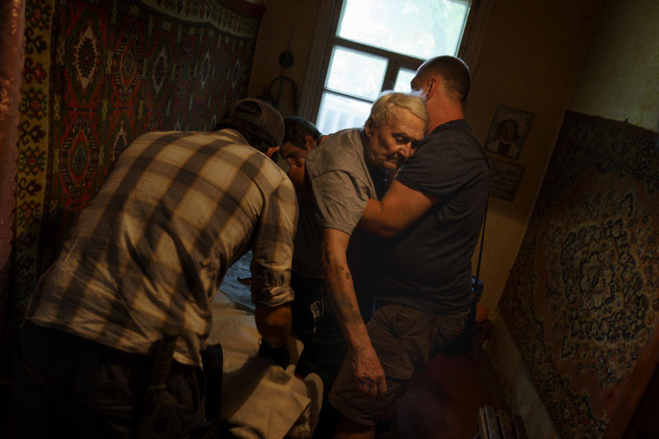 CORRECTS SPELLING TO VIKTOR NOT VICTOR Viktor Mariukha, 84, is lifted out of his bed by members of the aid organization Refugease as he's evacuated from his home in Kramatorsk, Donetsk region, eastern Ukraine, to board a train to a safer part of the country in the west, Tuesday, Aug. 2, 2022. The government issued an order to residents to leave the Donetsk region as they're preparing for the cold months of fall and winter and fear that many there may not have access to heating or electricity, or even clean water. (AP Photo/David Goldman)