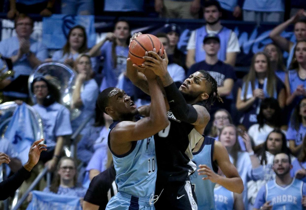 Cyril Langevine, left, of URI and Nate Watson of PC battle for a rebound during a game that the Rams won, 75-61, on Dec. 6, 2019.