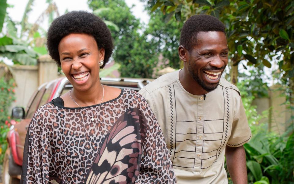 Ugandan presidential candidate Bobi Wine laughs with his wife Barbara Itungo Kyagulanyi after attending a press conference at his home before going to cast their ballots in the presidential elections in Kampala - Shutterstock