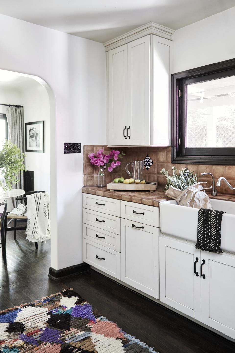 The color scheme in the kitchen is black, white, and copper tones, "and I’ve got this really colorful Moroccan rug on the ground," says Spencer.