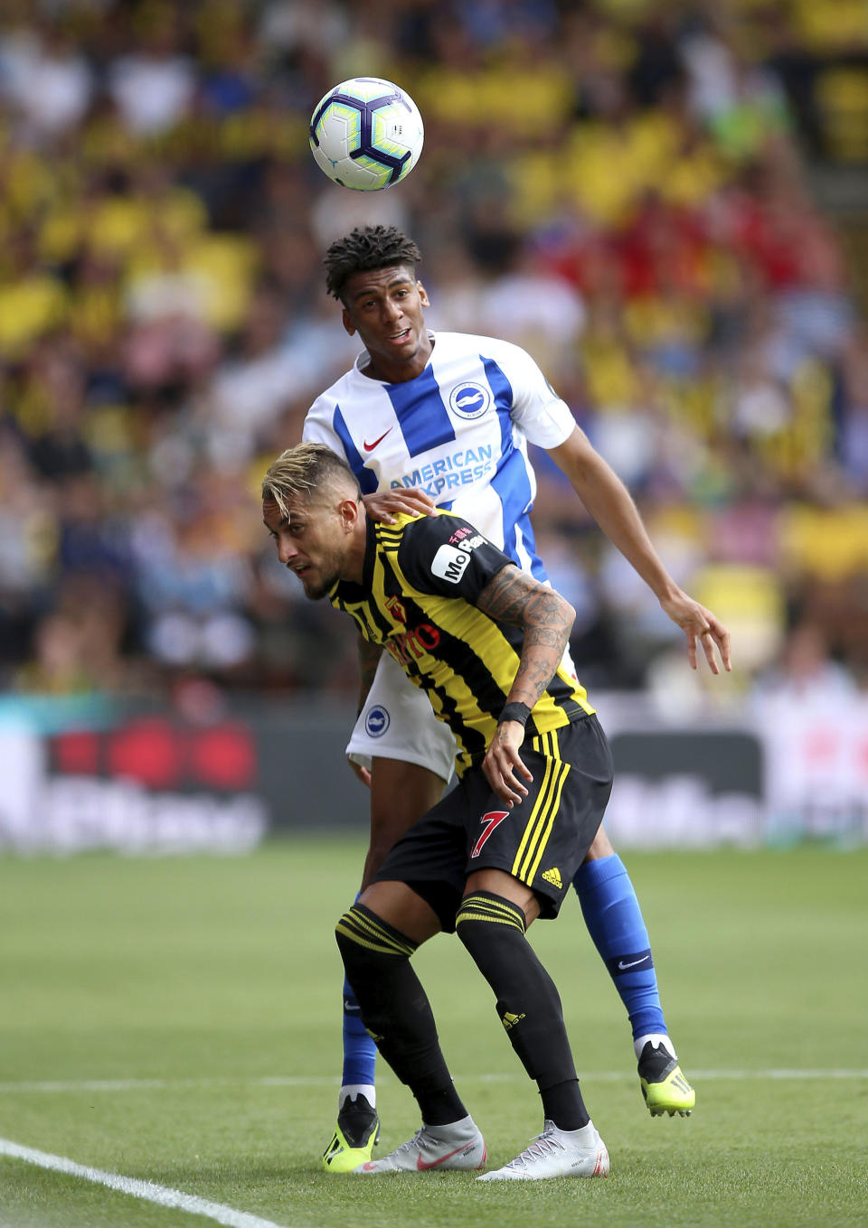 Watford's Roberto Pereyra, front, and Brighton & Hove Albion's Bernardo during their English Premier League soccer match at Vicarage Road in London, England, Saturday Aug. 11, 2018. (Nigel French/PA via AP)