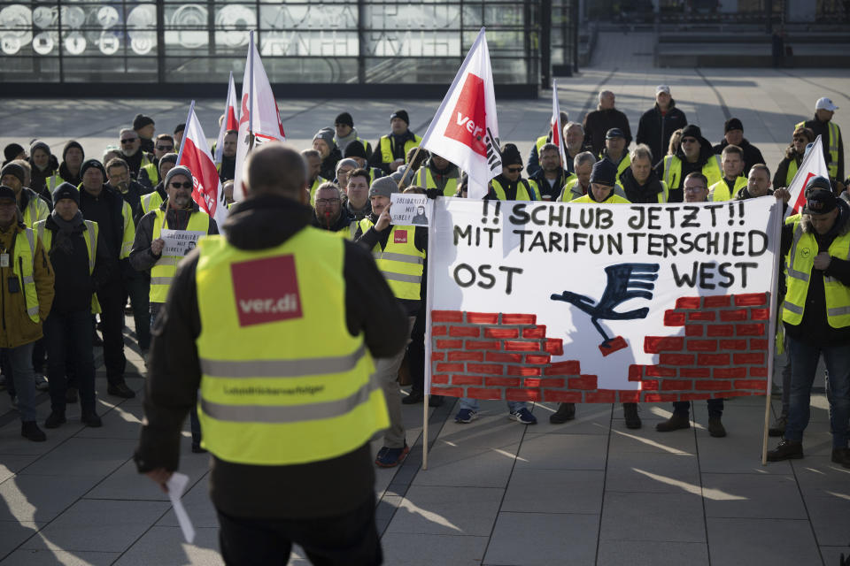 Strikers carry a banner that reads "No more wage differences East-West" during a Verdi rally at Berlin Brandenburg Airport, Germany, Thursday March 7, 2024. With renewed warning strikes by several professional groups, the Verdi union is paralyzing important parts of German air traffic on Thursday and Friday. (Sebastian Gollnow/dpa via AP)