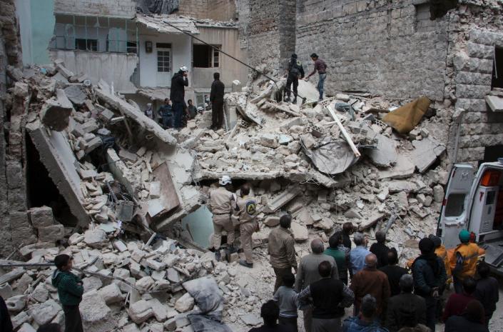 People inspect a destroyed building following a reported air strike by government forces on the rebel held area in the east of the northern Syrian city of Aleppo on April 13, 2015 (AFP Photo/Karam Al-Masri)