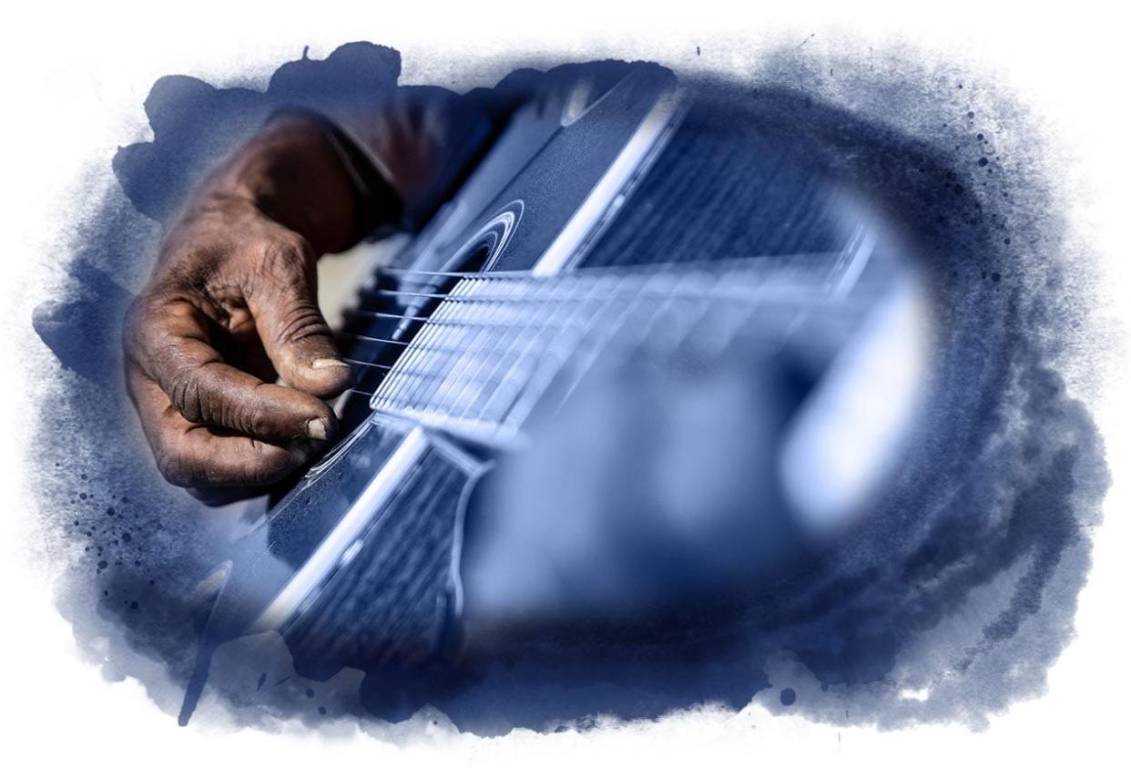 Jimmy “Duck” Holmes plays his guitar in front of the Blue Front Café in Bentonia, Miss.