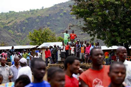 Relatives and friends wait during the second day of rescue operations after a boat carrying mostly Congolese refugees capsized in Lake Albert along the Uganda-Democratic Republic of Congo border, March 23, 2014. REUTERS/Edward Echwalu