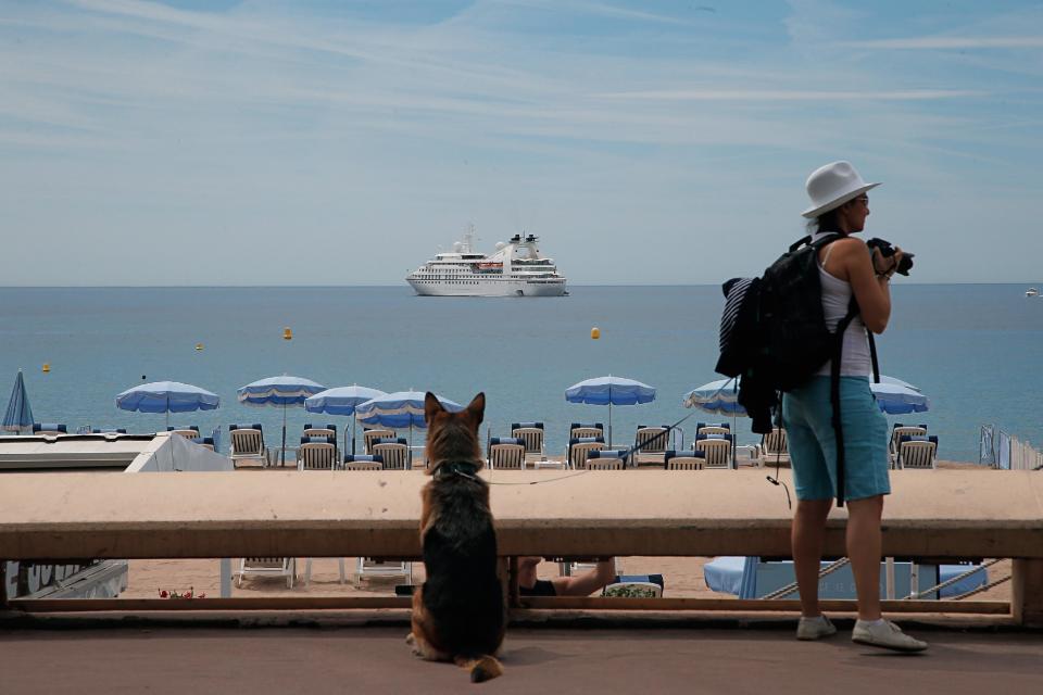 A woman and her dog take a walk on the croisette, in Cannes, southern France, Monday, May 12, 2014. The festival runs from May 14 to May 25. (AP Photo/Thibault Camus)