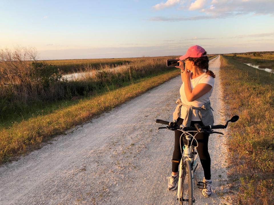 Liz Capozzi of Lake Worth Beach photographs deer from the main bike trail on the levee at the Loxahatchee National Wildlife Refuge.