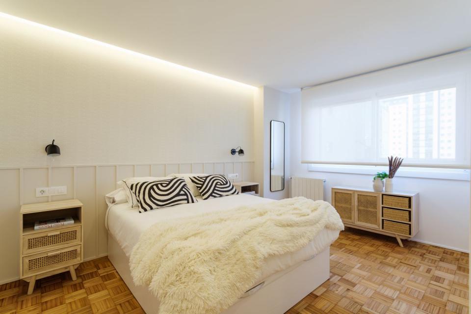 dormitorio con arrimadero como cabecero y muebles de madera y rejilla