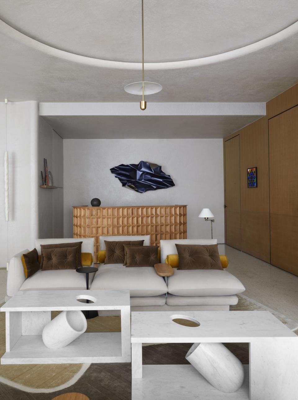 A muted grey living room with grey sofas and brown pillows