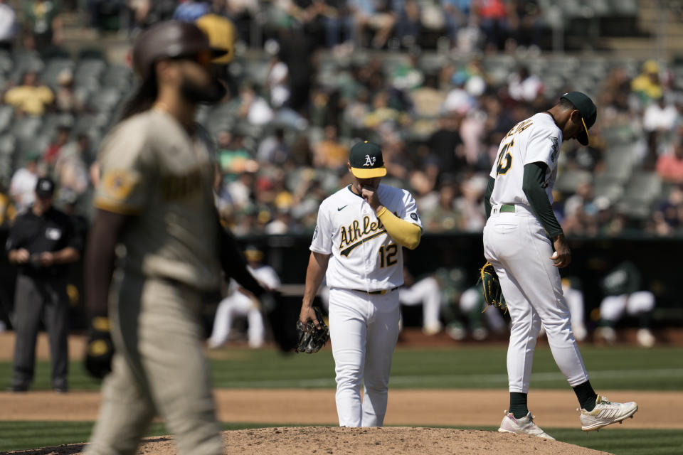 Oakland Athletics pitcher Luis Medina, right, stands on the mound after walking San Diego Padres' Fernando Tatis Jr., foreground left, during the fourth inning of a baseball game, Saturday, Sept. 16, 2023, in Oakland, Calif. (AP Photo/Godofredo A. Vásquez)