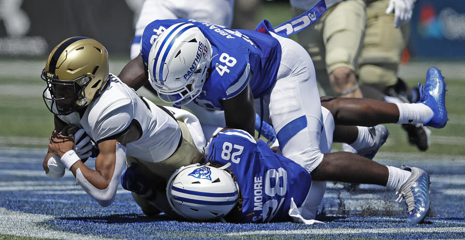 Army quarterback Christian Anderson, left, is tackled by Georgia State's Justin Abraham (48) and Chris Moore (28) during the first half of an NCAA football game Saturday, Sept. 4, 2021, in Atlanta. (AP Photo/Ben Margot)