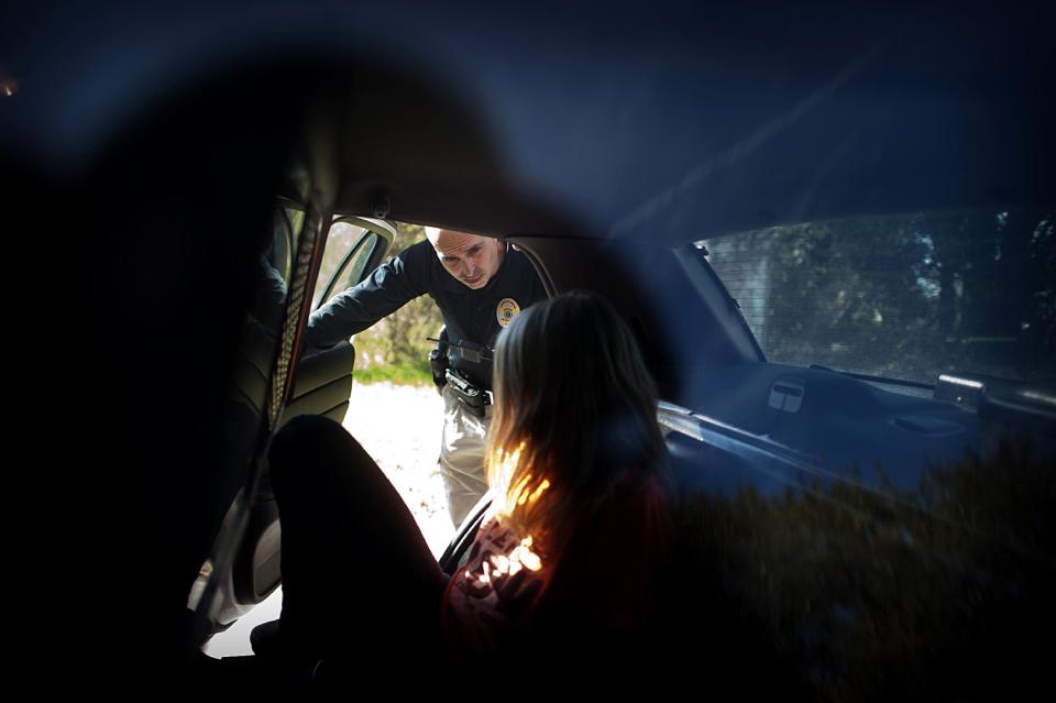 In this Friday, Feb. 7, 2014 photo, Homeless Liaison Officer Tom Gentner talks to one of the homeless residents he keeps track of after she was arrested for prostitution on the west side of Savannah, Ga. Gentner spotted the woman in an area known for prostitution outside his precinct boundaries and organized a sting operation earlier in the morning. (AP Photo/Stephen B. Morton)