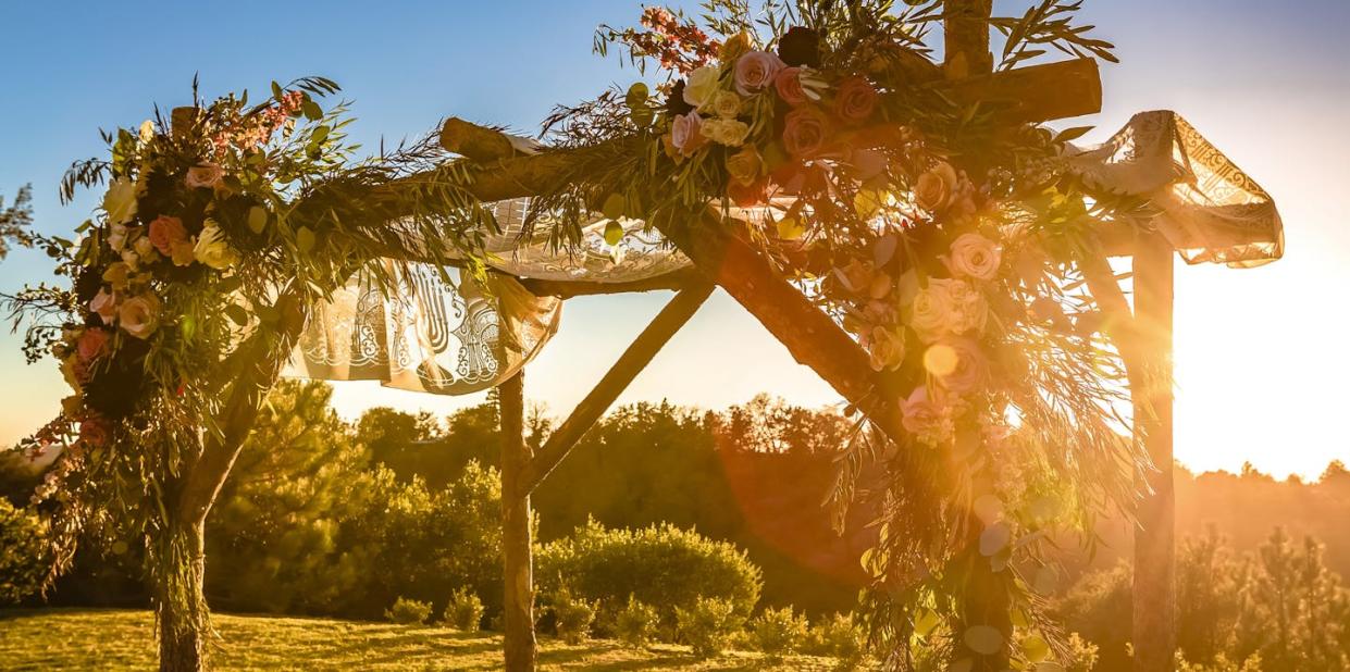 A chuppah is used in many Jewish weddings, but how it's decorated can weave other cultures into the ceremony, too. <a href="https://www.gettyimages.com/detail/photo/chuppah-with-the-setting-sun-in-the-background-royalty-free-image/1045693406?phrase=chuppah&adppopup=true" rel="nofollow noopener" target="_blank" data-ylk="slk:Jason Finn/iStock via Getty Images Plus;elm:context_link;itc:0;sec:content-canvas" class="link ">Jason Finn/iStock via Getty Images Plus</a>