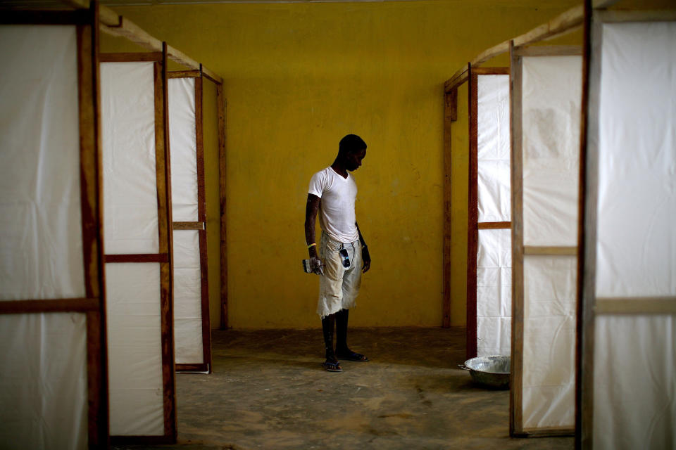 A worker stands by dividers to separate patients in an Ebola treatment facility under construction in the Port Loko district of Sierra Leone, in November 2014.