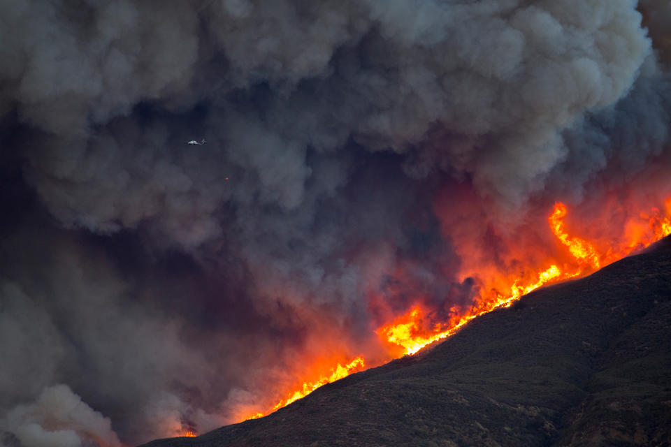 <p>Smoke and flames consume a helicopter hovering above the Thomas Fire on December 7 near Fillmore, California.</p>