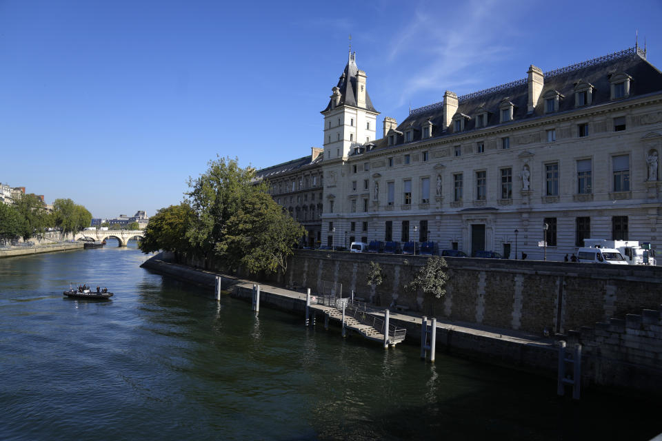 Police river forces patrol on the Seine river outside at the Palace of Justice, right, Wednesday, Sept. 8, 2021 in Paris. France is putting on trial 20 men accused in the Islamic State group's 2015 attacks on Paris that left 130 people dead and hundreds injured. The proceedings begin Wednesday in an enormous custom-designed chamber. Most of the defendants face the maximum sentence of life in prison if convicted of complicity in the attacks. Only Abdeslam is charged with murder. (AP Photo/Francois Mori)