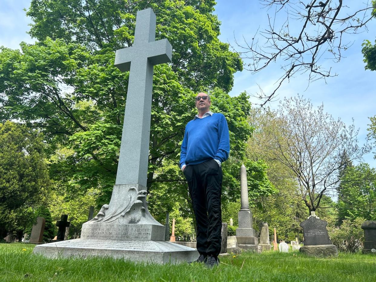 Doug Paterson, a lifelong Balsam Lake resident, stands next to the refurbished monument to the 11 boys and young men who lost their lives on Balsam Lake in 1926. (Mike Smee/CBC - image credit)