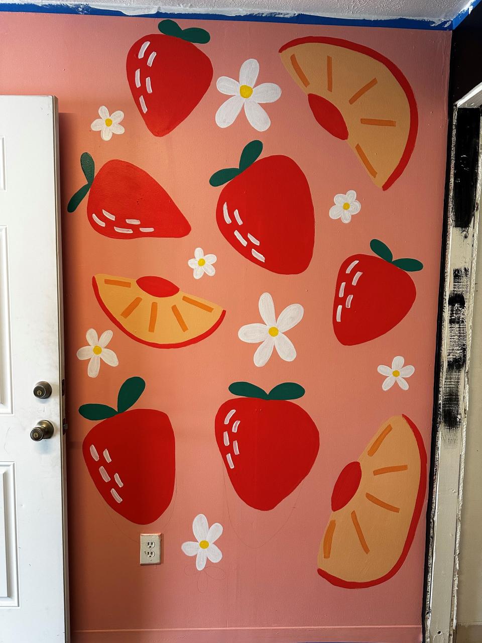Sam Kearney, owner of Roll Up Herbal Bar, painted a mural of fruits inside the mocktail bar's new brick-and-mortar in Waynesville.