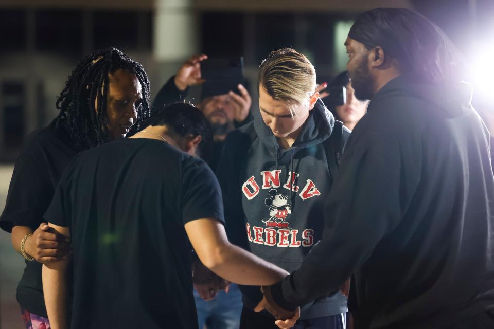 University of Nevada, Las Vegas, student Carlos Casillas, 23, second from right, prays at the Las Vegas Convention Center reunification area where he was transported after a fatal shooting at the campus in Las Vegas, Wednesday, Dec. 6, 2023.