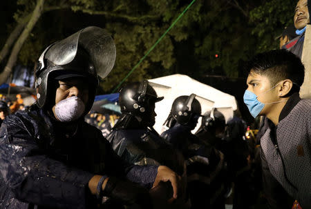 Relatives protest next to police officers, in front of a collapsed building, after the earthquake in Mexico City, Mexico September 25, 2017. REUTERS/Nacho Doce