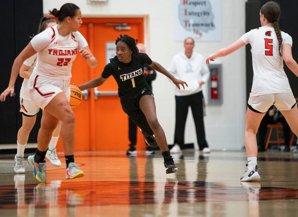 Golden Gate Titans guard Eslynda Bouzi (1) handles the ball during the second half of the Class 5A-District 12 semifinal against the Lely Trojans at Lely High School on Wednesday, Feb. 7, 2024.