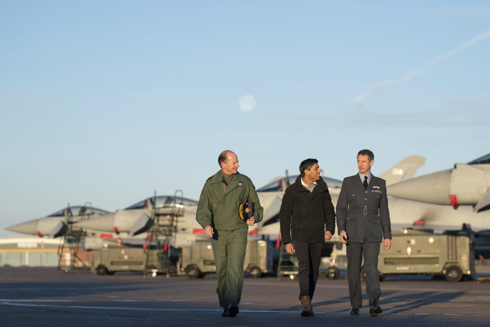 Air Chief Marshal Mike Wigston, left and Station Commander for RAF Coningsby Billy Cooper walk with Britain's Prime Minister Rishi Sunak during his visit to RAF Coningsby in Lincolnshire, England, Friday, Dec. 9, 2022, following the announcement that Britain will work to develop next-generation fighter jets with Italy and Japan. (Joe Giddens/Pool Photo via AP)