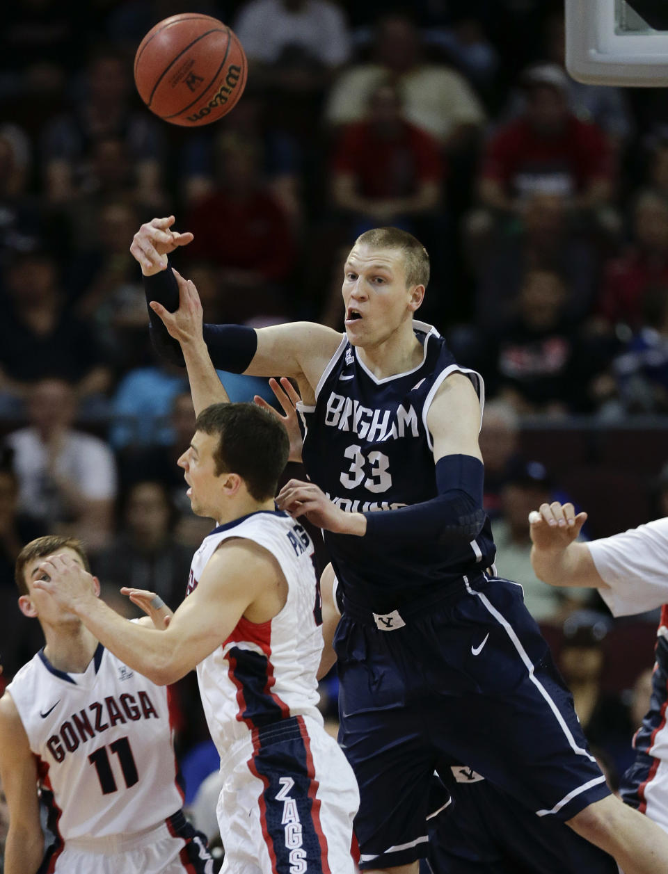 BYU's Nate Austin (33) passes the ball over Gonzaga's Kevin Pangos in the first half of the NCAA West Coast Conference tournament championship college basketball game, Tuesday, March 11, 2014, in Las Vegas. (AP Photo/Julie Jacobson)