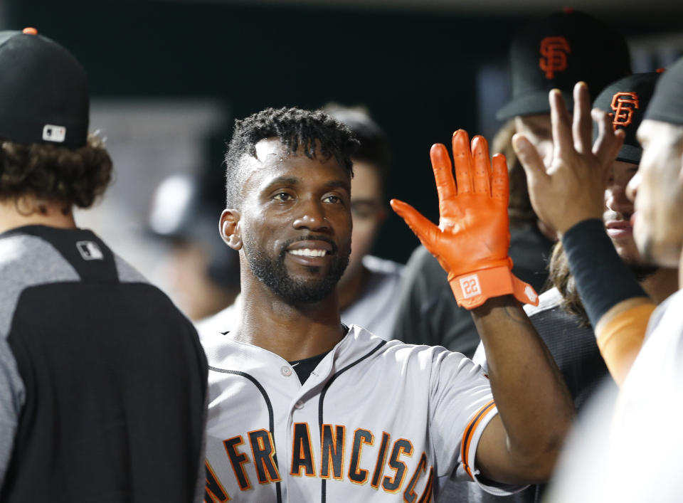 FILE - In this Aug. 18, 2018, file photo, San Francisco Giants' Andrew McCutchen, center, is congratulated in the dugout after scoring during the eighth inning of a baseball game against the Cincinnati Reds, in Cincinnati.The playoff-contending New York Yankees are close to completing a trade for San Francisco Giants outfielder Andrew McCutchen. A person familiar with the negotiations told The Associated Press on Thursday night, Aug. 30, 2018, the Yankees would send infielder Abiatal Avelino and another minor leaguer to San Francisco for McCutchen. The person spoke on condition of anonymity because the deal wasn't finalized. (AP Photo/Gary Landers, File)